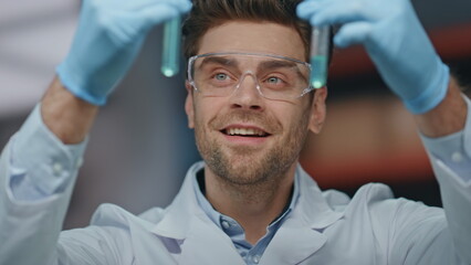 Laboratory worker looking test tubes satisfied research results in lab close up