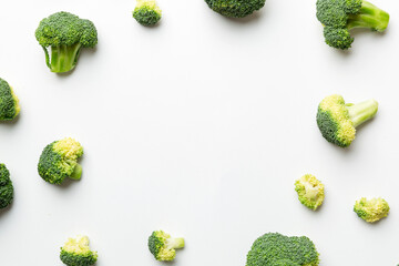 Flat lay composition with fresh green broccoli frame eith copy space on light background