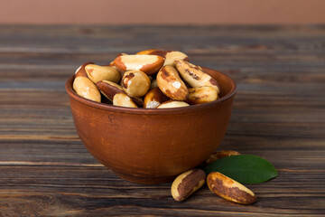 Fresh healthy Brazil nuts in bowl on colored table background. Top view Healthy eating bertholletia concept. Super foods