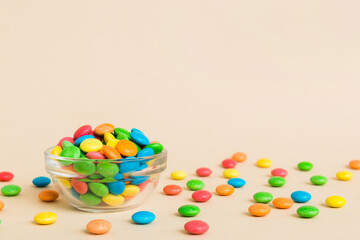 Multicolored candies in a bowl on a colored background. birthday and holiday concept. Top view with copy space