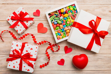 Valentine day composition: sweet candy, with gift boxes with bow and red felt hearts, photo template, background. Top View with copy space
