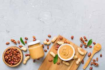 Bowl of peanut butter and peanuts on table background. top view with copy space. Creamy peanut...
