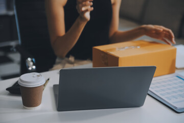 businesswoman start small business and successful SME entrepreneurs asian woman hoding boxs works from home delivering parcels online. SME delivery concept and packaging