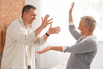 Angry mature couple quarreling at home
