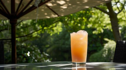 Peach Cooler Cocktail on Outdoor Table with Umbrella Shade in Garden.