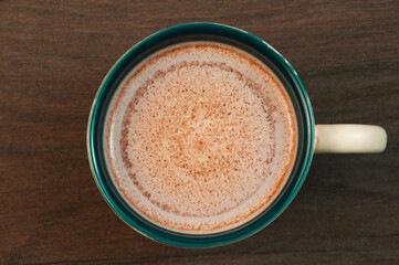 latte in a clay cup on the table. cocoa drink in a cup on a wooden background