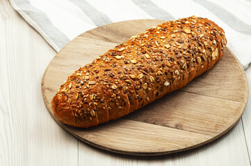 black sliced bread with bran on a brown table. oval dark bread on light texture