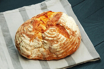 delicious Italian bread on a blue background. appetizing homemade bread on dark wooden texture. ciabatta on a white towel on the table