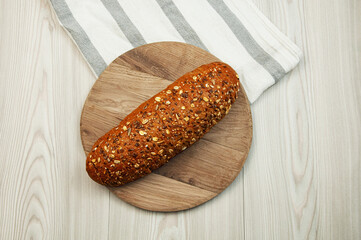 black sliced bread with bran on a brown table. oval dark bread on light texture	