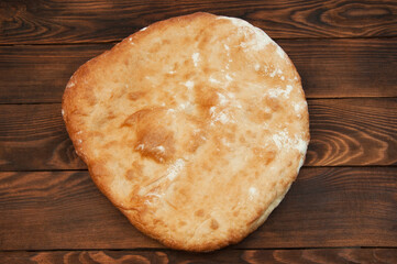 round georgian lavash on a wooden background. chapati fresh bread on a brown texture