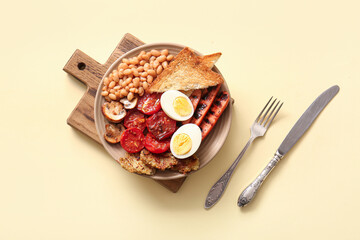Plate of tasty English breakfast with boiled egg on yellow background