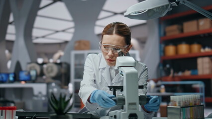 Professional scientist looking microscope analyzing sample closeup. Woman doctor