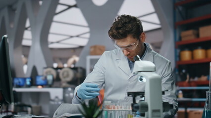 Laboratory scientist researching disease in clinic close up. Man holding samples