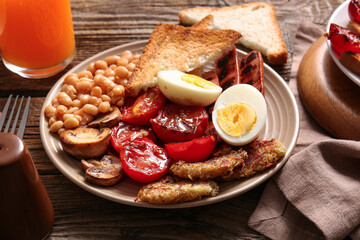 Plate of tasty English breakfast with boiled egg on wooden background