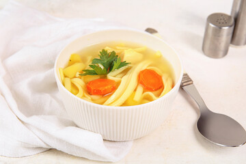 Bowl of tasty chicken soup on white background