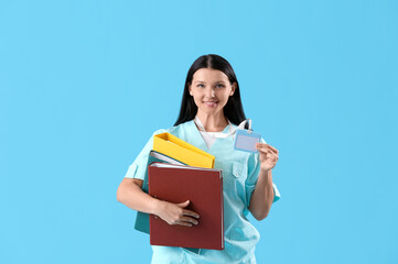 Obraz premium Female medical student with folders on blue background