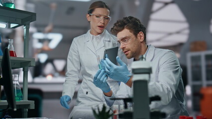 Woman scientist teach assistant to make research in lab. Dissatisfied doctor