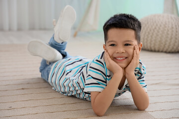 Little Asian boy lying on floor at home © Pixel-Shot