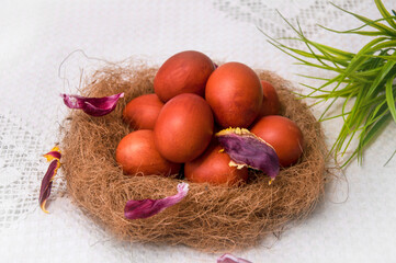 Easter eggs in a nest on a white tablecloth. Close-up
