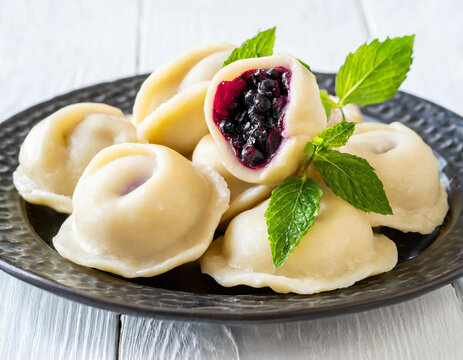 Vareniki with berry filling, blueberry dumplings isolated on white background