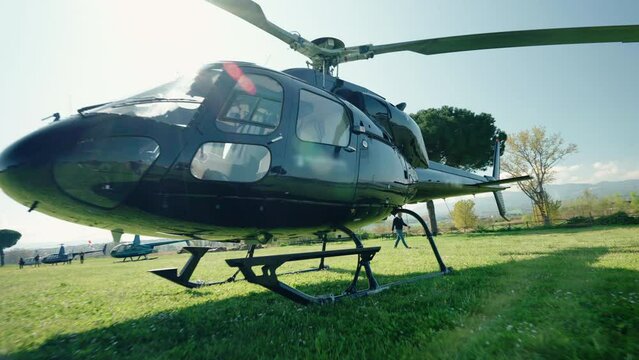 Dolly in shot of helicopter on private airfield against sunshine background, air vehicle for feeling flying experience, adrenaline and adventure concept