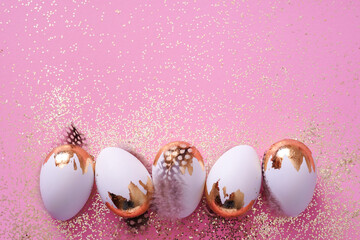 Easter party concept. white Easter eggs with golden glitter on pink background