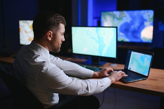 Male Data Scientist Works on Personal Computer Control and Monitoring Room. Map Surveillance of People Walking on City Streets