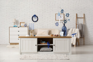 Interior of festive living room with decorations for Hanukkah celebration on wooden table
