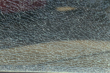 Close up of a shattered glass fence in the city.