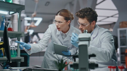 Obraz premium Woman biochemist discussing medical research with man colleague in lab close up.
