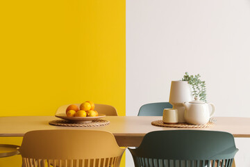 Citruses with plant and teapot on dining table near color wall in room