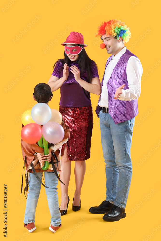 Poster Happy family in costumes and carnival masks on yellow background