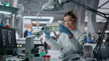 Specialist examining test tubes in laboratory close up. Woman scientist working