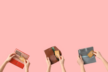 Women with credit cards in wallets on pink background