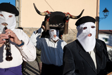 Encapuchados músicos y disfraces de toro en un carnaval en un pueblo español de Guadalajara.