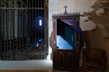 Interior de iglesia con un viejo confesionario en primer término, España.