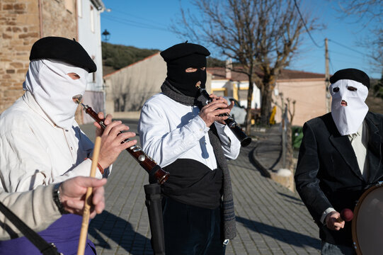 Dulzaineros encapuchados tocan m&uacute;sica tradicional en una fiesta de carnaval en un pueblo de Guadalajara, Espa&ntilde;a.
