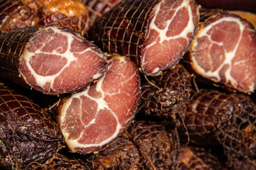Delicious pieces of smoked meat exposed for sale in the market  presented for sale on a farmer's...