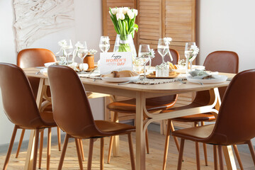 Dining table with setting and beautiful tulip flowers served for International Women's Day celebration