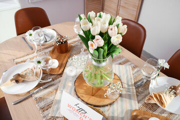 Beautiful table setting with tulips and greeting card for International Women's Day celebration