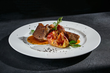 Beef tongue with roasted potatoes on a white plate