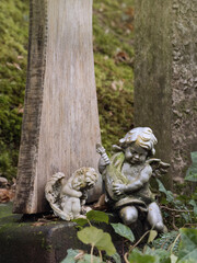 Kleine sitzende Engelsfiguren an Stein, im Park