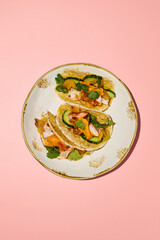 Top view of sweet potato mousse and turkey tacos on a gold-rimmed plate against a pink backdrop