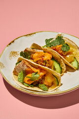 Close-up of sweet potato mousse and turkey tacos on a vintage plate, with a pink background