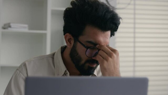 Upset disappointed Indian muslim guy businessman male entrepreneur stressed frustrated Arabian business man looking at laptop pc at office stress problem fail with computer money loss bankrupt failure