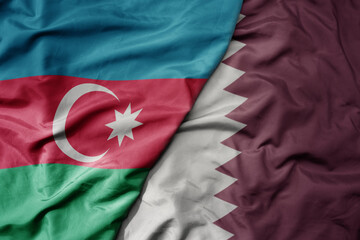 big waving national colorful flag of qatar and national flag of azerbaijan.