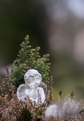 Kleiner heller Engel in Blumen sitzend