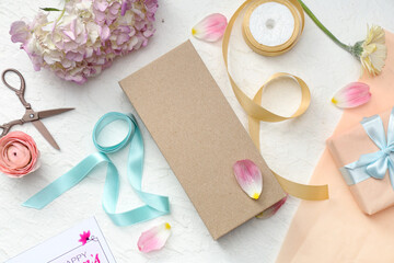 Gift boxes with wrapping paper and beautiful flowers on white background. International Women's Day