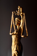 statuette of the Greek goddess of justice Themis in profile on a dark background