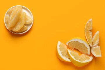 Plate with sweet pomelo pieces and slices on orange background